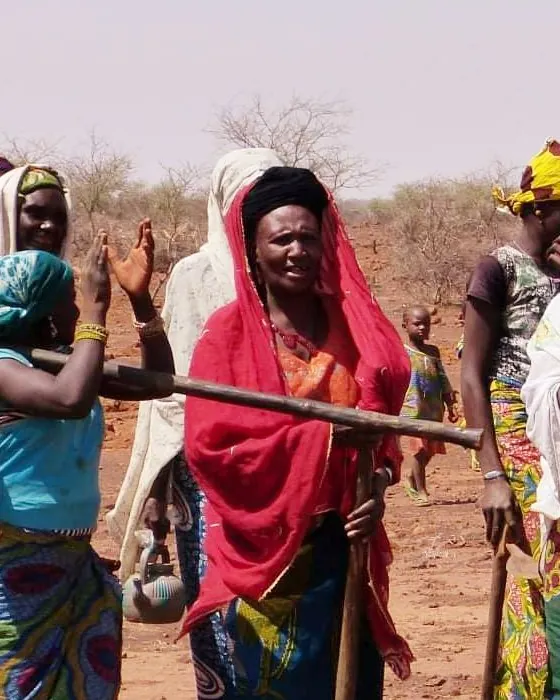 A Haratine woman in a red shawl in the Sahel, looking towards the camera.
